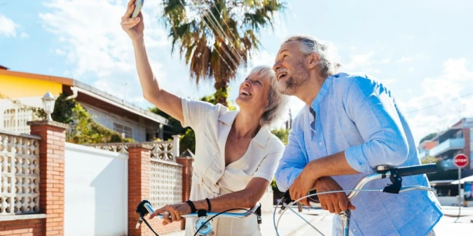 An older couple enjoying a bicycle ride in their neighborhood